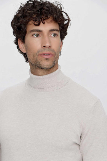 Man wearing a light beige basic turtleneck sweater, relaxed fit, against white background