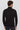 Back view of man wearing a black turtleneck sweater and dark jeans