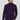 Man wearing a dark purple turtleneck sweater and light grey pants against a plain background