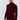 Man wearing a slim-fit burgundy turtleneck sweater and grey trousers