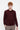 Man wearing a burgundy crew neck sweater with relaxed fit and beige trousers