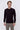 Man wearing a black crew neck long sleeve sweater and light grey trousers