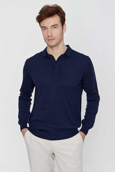 Man wearing a navy blue long sleeve polo shirt with beige trousers, front view