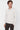 Man wearing a light beige long sleeve polo shirt with a relaxed fit, casual fashion style