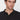 Man wearing a black polo neck shirt with a relaxed fit, modern casual style