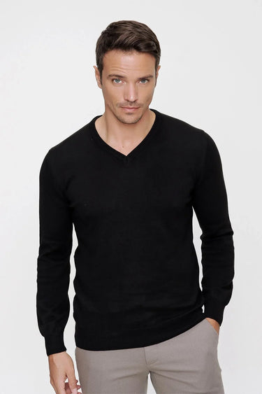 Man wearing a black V-neck long sleeve shirt with relaxed fit and beige trousers