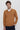 Man wearing camel V-neck long sleeve sweater over white shirt, relaxed fit, neutral background