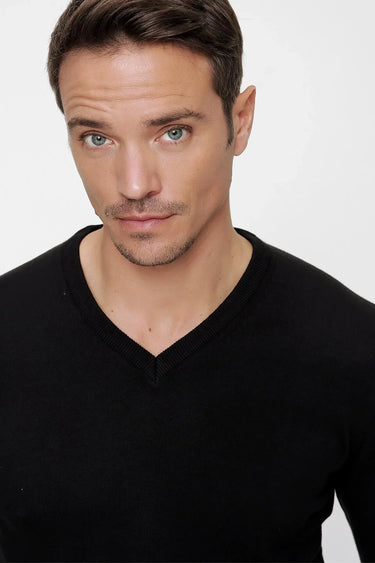 Man wearing a black V-neck t-shirt with relaxed fit, close-up studio shot