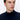 Man wearing a navy blue turtleneck sweater on white background