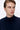 Man wearing a navy blue turtleneck sweater on white background