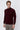 Man wearing a burgundy long sleeve mock neck sweater and light grey trousers