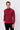 Man wearing a red long sleeve turtleneck sweater and black trousers on plain background
