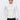 Man wearing a white long sleeve mock neck sweater and dark trousers against plain background