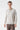 Man wearing a beige long sleeve polo shirt with relaxed fit, standing against white background