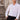 Man wearing white slim fit dress shirt and black pants standing by stone steps