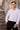 Man wearing white slim fit dress shirt and black pants standing by stone steps