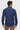 Man wearing a navy blue slim fit long sleeve shirt, back view, with brown pants