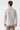 Back view of a man wearing a beige jacquard knit zip sweater and taupe trousers