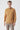 Man wearing camel basic half turtleneck sweater and beige pants on white background