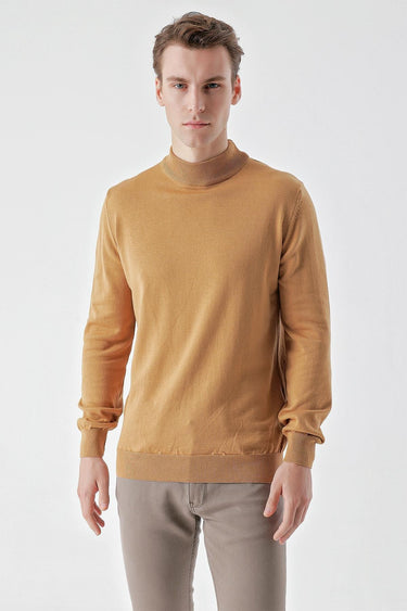 Man wearing camel basic half turtleneck sweater and beige pants on white background