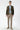 Man wearing olive green slim fit blazer, light blue shirt, beige slim trousers and sneakers