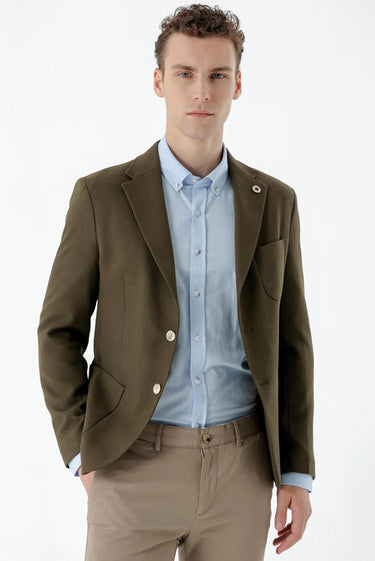 Man wearing khaki slim fit blazer, light blue shirt, and beige trousers, front view.