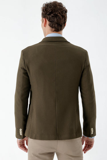 Back view of man wearing khaki slim fit woven blazer with buttoned cuffs and beige trousers