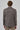 Back view of a man wearing a brown checked knit blazer and beige trousers