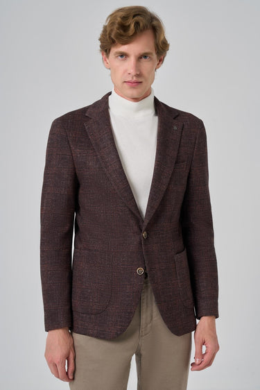 Man wearing brown checkered knit blazer, white turtleneck, and beige pants