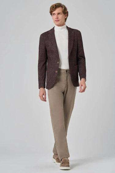 Man wearing brown checked blazer, white turtleneck, beige trousers and loafers