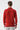 Man wearing a red long sleeve half turtleneck sweater, back view, with light grey pants