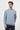 Man wearing a light blue crew neck sweatshirt with long sleeves and dark trousers.