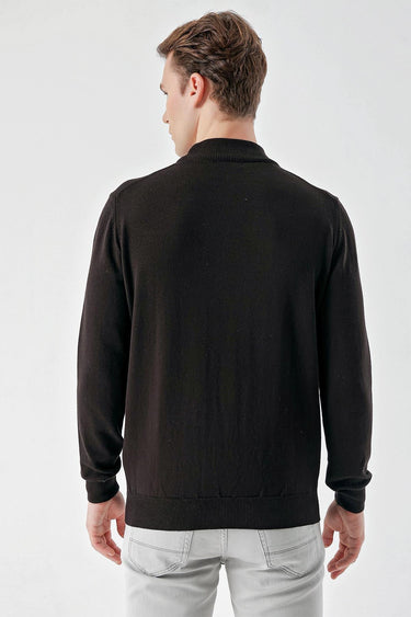 Man wearing black basic half turtleneck sweater, back view, with light grey jeans