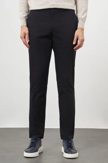 Men's black cotton slim fit trousers with side pockets, styled with sneakers