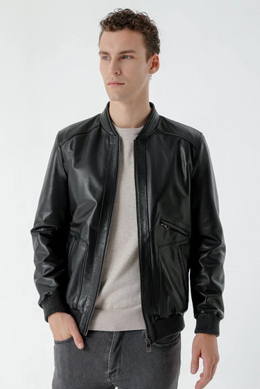 Man wearing black faux leather bomber jacket with zip front and ribbed cuffs