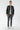 Man wearing black leather jacket, grey slim-fit jeans, white sneakers, light sweater