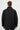 Rear view of a man wearing a black quilted long-sleeve jacket