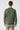 Man wearing green crew neck sweatshirt and beige pants, shown from the back