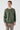 Man wearing a green crew neck long sleeve sweatshirt with beige trousers
