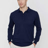Man wearing a navy blue long sleeve polo shirt with beige trousers, front view