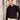 Man wearing black slim fit dress shirt and beige trousers standing outdoors