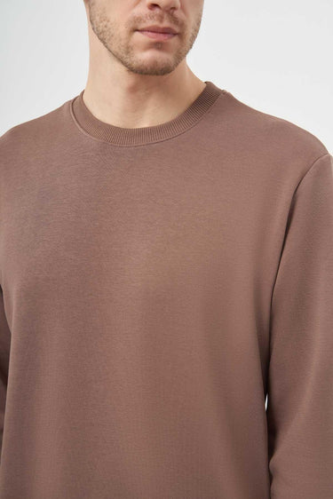 Man wearing a brown crew neck basic long sleeve t-shirt