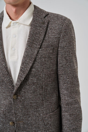 Men's brown plaid textured blazer with notch lapel and white shirt underneath