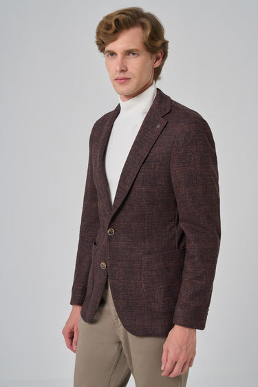 Man wearing a brown checked knit blazer with beige trousers and a white turtleneck