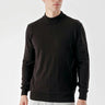 Man wearing a black basic half turtleneck sweater with long sleeves, light jeans, studio setting